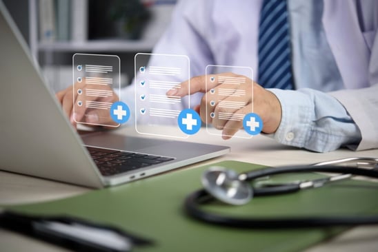 A person in a white coat uses a laptop with floating checklists and blue medical cross icons. 