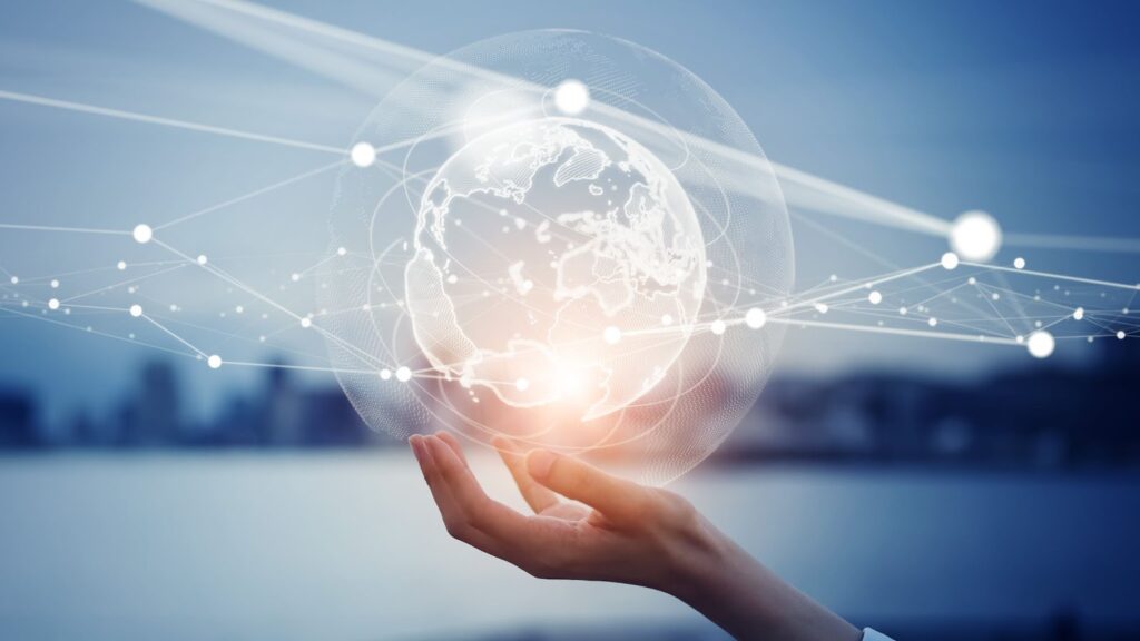 A hand gently supports a glowing digital globe with network connections against a blurred cityscape