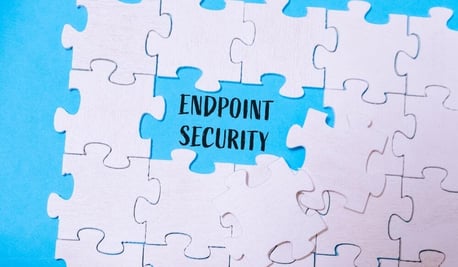 White puzzle pieces surrounding a blue center with the words "Endpoint Security," symbolizing how endpoint protection is a key piece of the cybersecurity puzzle.