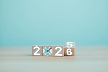 Wooden blocks showing the year change from 2025 to 2026 with a target symbol replacing the "0", symbolizing goal setting and looking ahead.