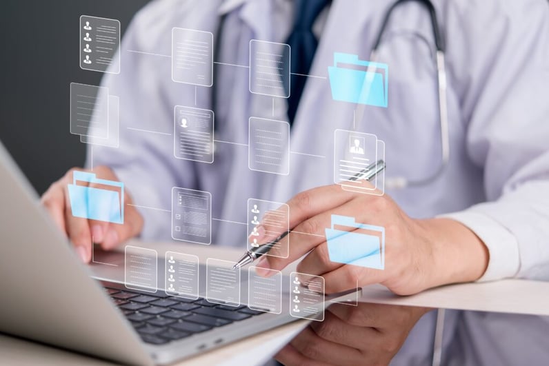 A doctor in a white coat uses a laptop, interacting with a digital interface showing interconnected folders and documents