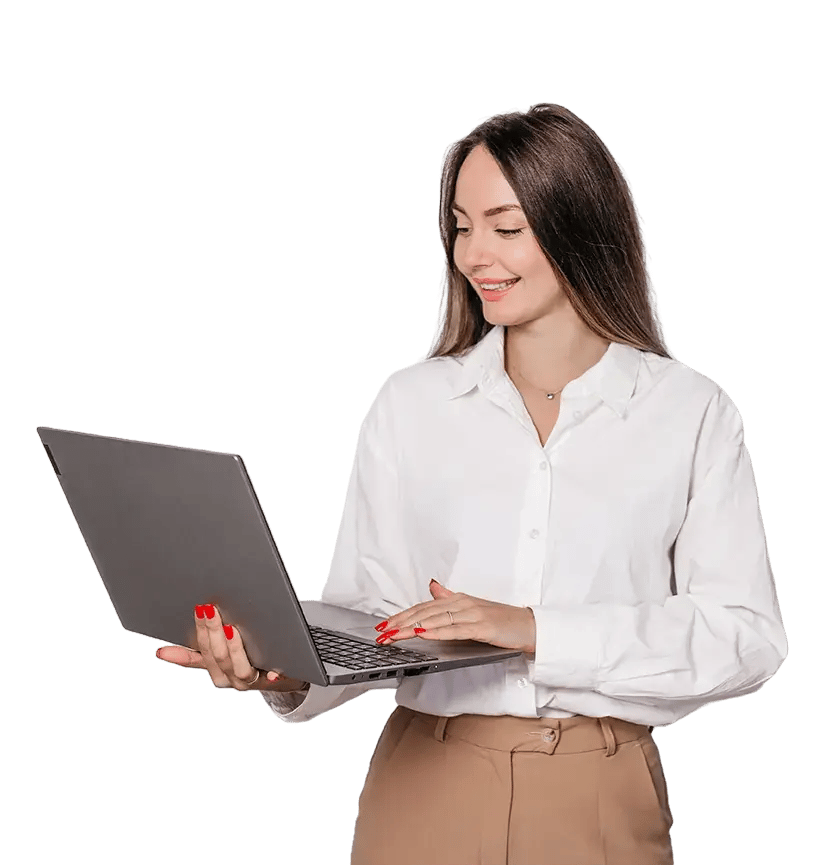 a women standing, holding and working on her laptop