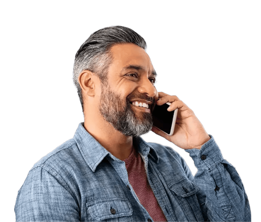 man smiling while holding his phone up to his ear.